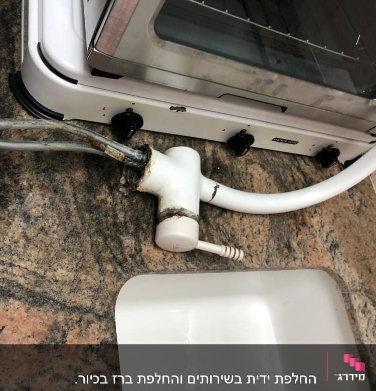 ברז מים עם צינור לבן על שיש מטבח